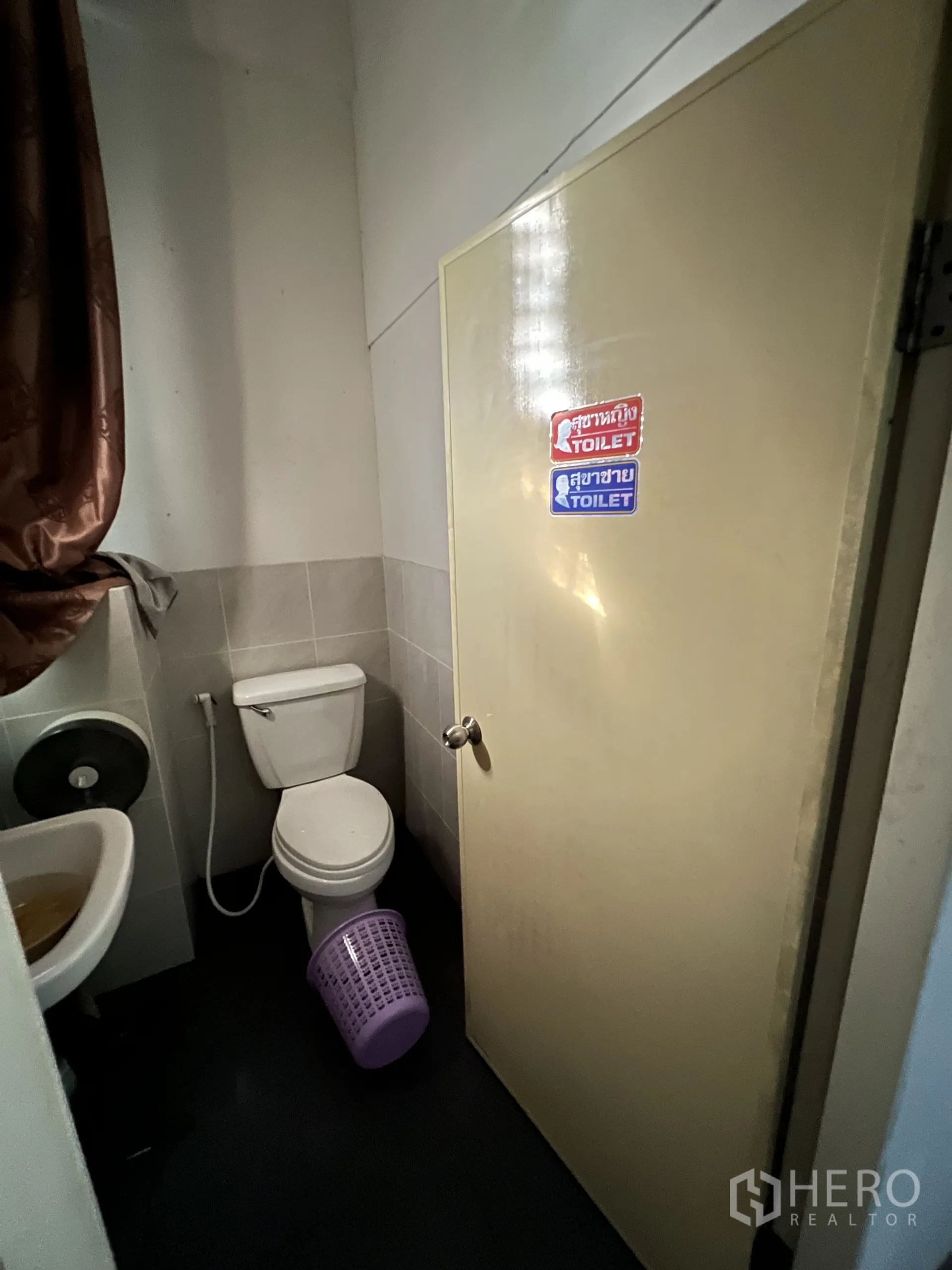 Shophouse for rent in Khlong Toei, Bangkok - Compact restroom with toilet, washbasin and a labeled door.