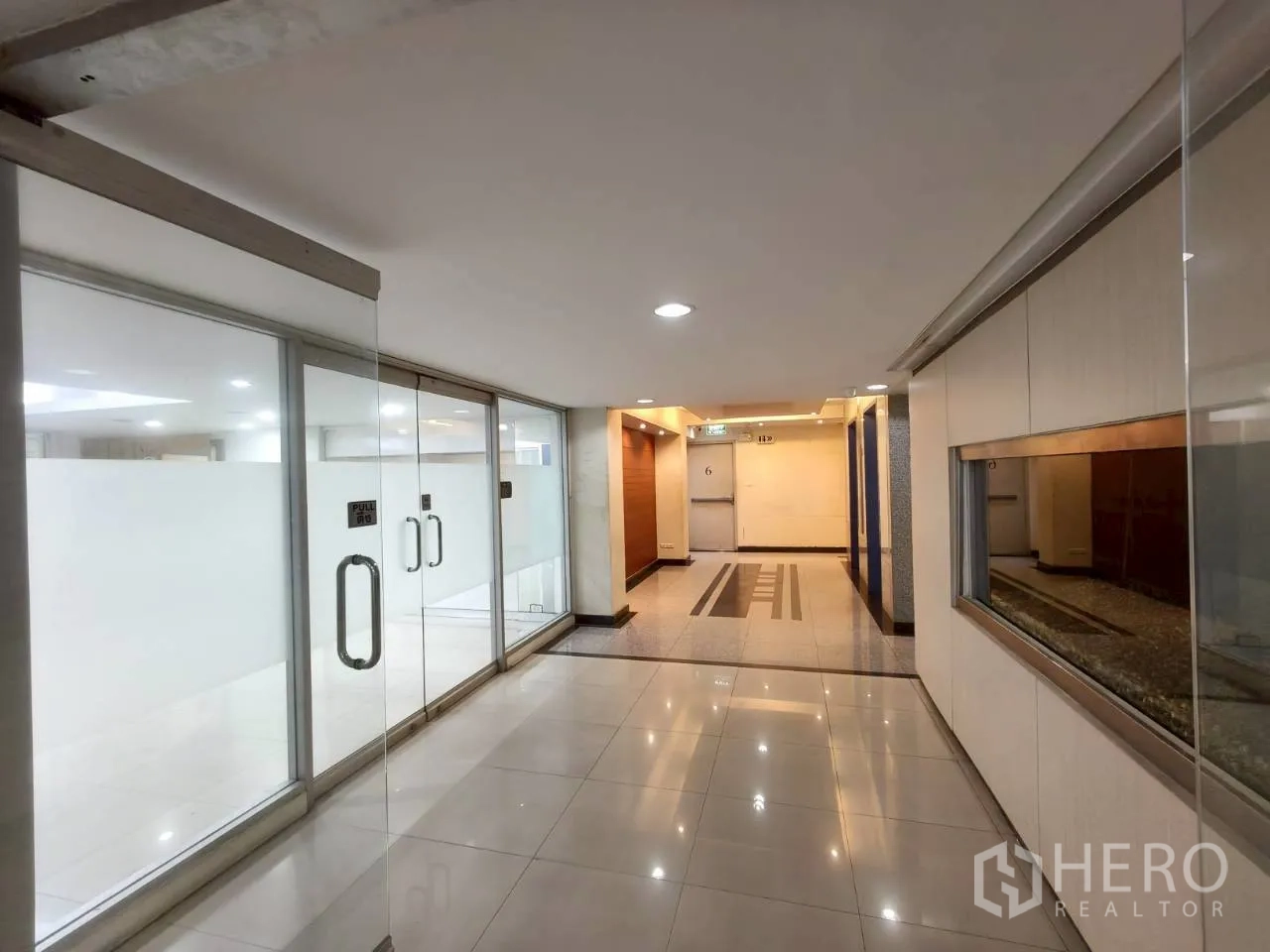 Office Space for rent in Chatuchak, Bangkok - Shared corridor with glass storefronts and polished tile walkway.