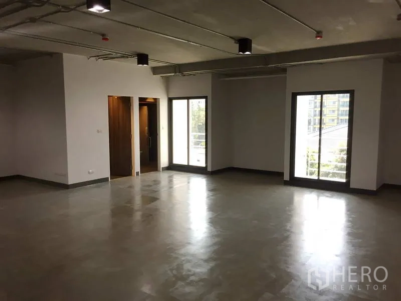 Office Space for rent in Khlong Toei, Bangkok - Bright office area with large windows and balcony access, polished floors, and open-plan layout.
