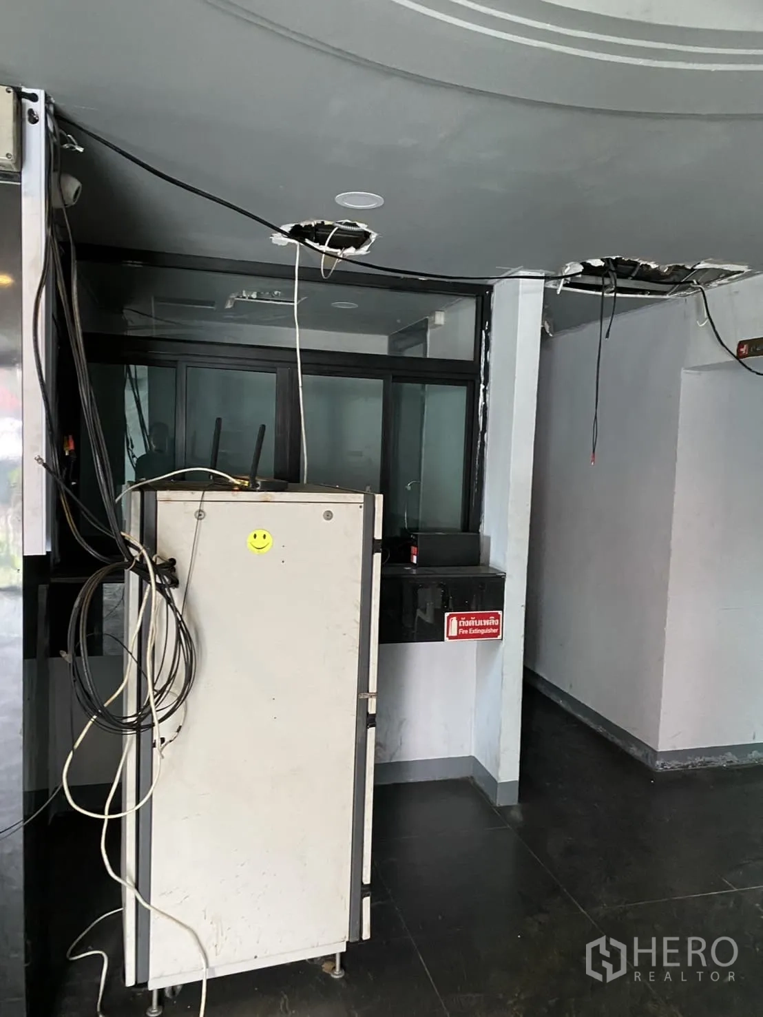 Showroom for rent in Lat Phrao, Bangkok - Lobby corner with wiring and a glass sliding door ready for fit-out.