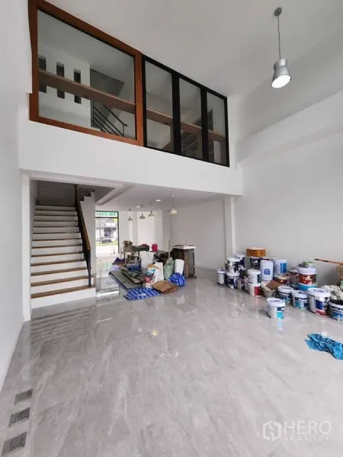 Warehouse for rent in Phra Khanong, Bangkok - Double-height warehouse space with mezzanine glazing, staircase and polished floors.