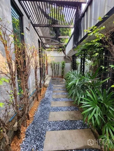 สำนักงานที่บ้าน ให้เช่าในLat Phrao, Bangkok - ทางเดินด้านข้างมีระแนงกันแดด โรยกรวดและแผ่นคอนกรีต ล้อมด้วยต้นไม้เมืองร้อน