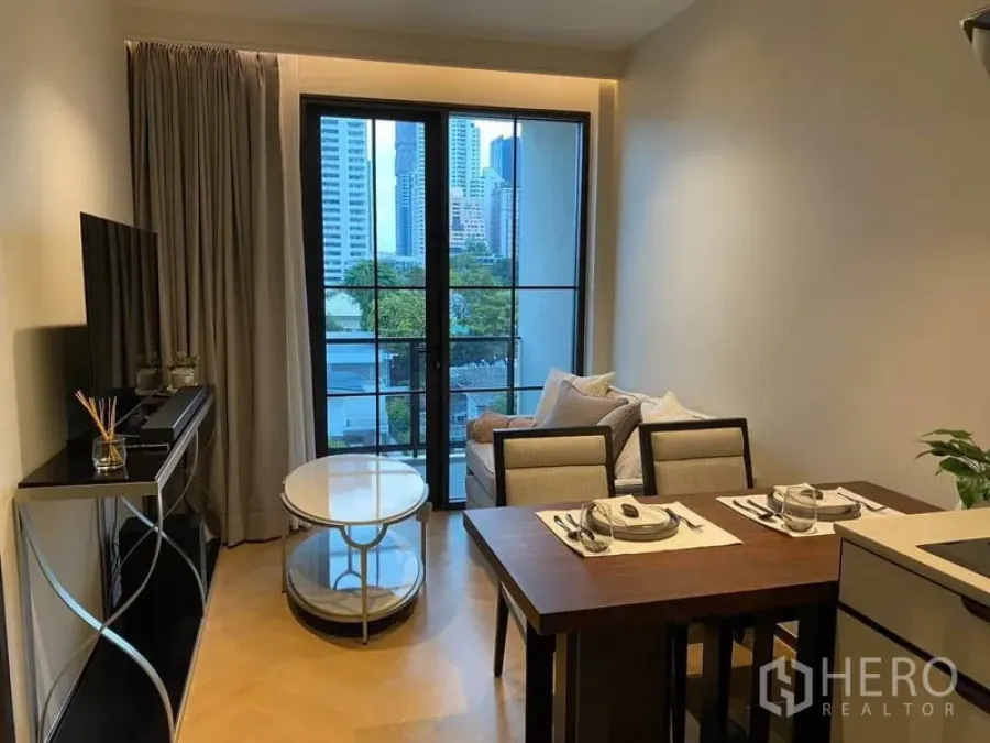 Condominium for rent in Watthana, Bangkok - Living and dining area with city view through large balcony doors near Ekkamai BTS.