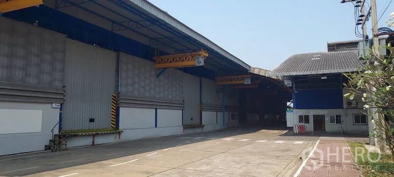 Factory for rent in Phra Pradaeng, Samut Prakan - Driveway between warehouses with dock shelters and zebra crossings.