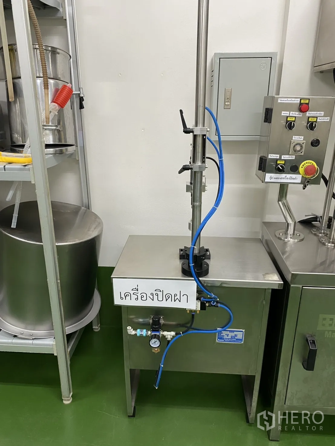 Factory for sale in Khlong Luang, Pathum Thani - Close-up of a stainless capping machine in a clean processing room.