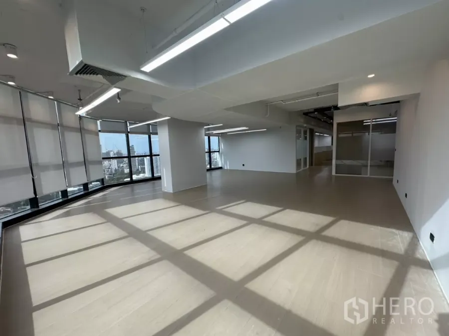 Office Space for rent in Watthana, Bangkok - Sunlit open-plan office with floor-to-ceiling windows and city views.