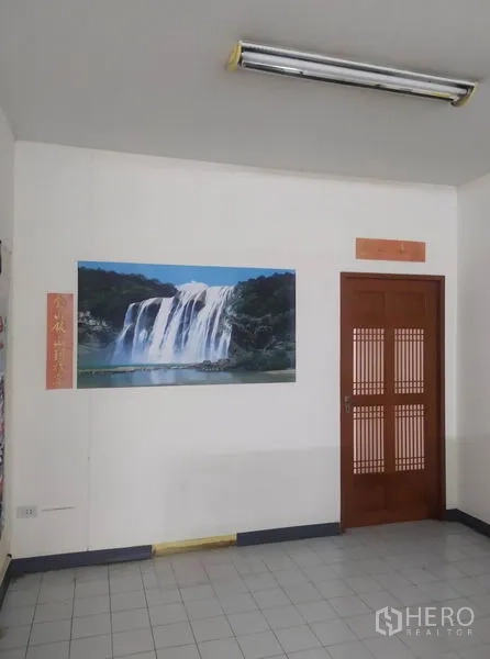 Home Office for rent in Yan Nawa, Bangkok - Interior corner with wooden door and waterfall wall art under ceiling light.