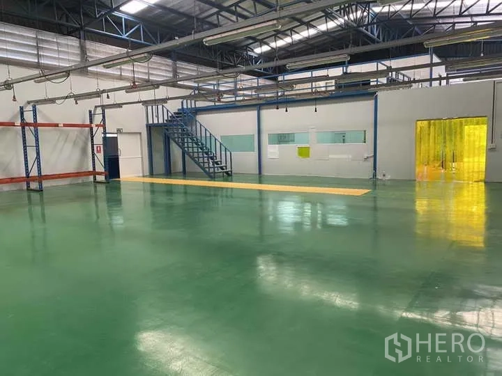 Factory for rent or sale in Bang Yai, Nonthaburi - Spacious production hall with green epoxy floor, mezzanine and PVC strip door.
