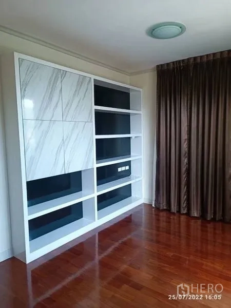 Detached House for sale in Prawet, Bangkok - Built-in storage wall with open shelving and marble-effect panels in a bright room.