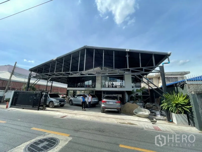 สำนักงานที่บ้าน ให้เช่าในWang Thonglang, Bangkok - ภาพกว้างด้านหน้าอาคารสไตล์อินดัสเทรียล พร้อมกันสาดขนาดใหญ่และพื้นที่จอด