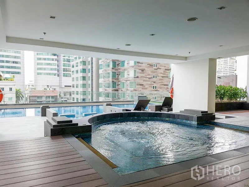 Apartment for rent in Khlong Toei, Bangkok - Covered pool deck with circular jacuzzi, lap pool and city views at a Khlong Toei apartment building.