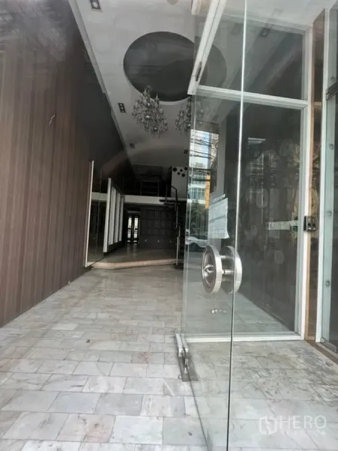 อาคารพาณิชย์ ให้เช่าในWatthana, Bangkok - ประตูกระจกทางเข้าเปิดสู่พื้นที่ร้านยาว เพดานสูงพร้อมโคมระย้า